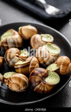 Escargots au beurre de persil, escargots d'Escargot de Bourgogne sur l'assiette. Cuisine Delikatese. Banque D'Images