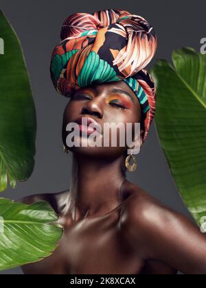 Parfois, les accessoires les plus simples parlent le plus fort. Studio photo d'une belle jeune femme portant une tête africaine traditionnelle enveloppée d'un feuillage Banque D'Images