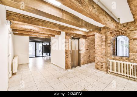 Staircase and elevator located near door and brick wall in hall of contemporary apartment building Stock Photo