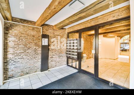 Staircase and elevator located near door and brick wall in hall of contemporary apartment building Stock Photo