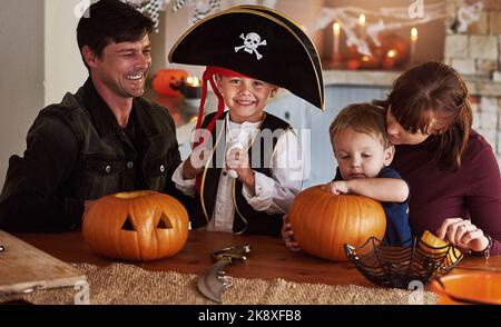 Ahoy matey des temps effrayants arrivent. Portrait d'un adorable jeune garçon habillé comme un pirate célébrant Halloween avec sa famille à la maison. Banque D'Images