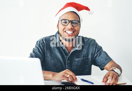 Je me sens festif et productif aujourd'hui. Portrait d'un beau jeune homme d'affaires travaillant dans son bureau la veille de Noël. Banque D'Images