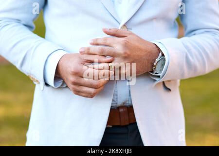 Je me sent bien d'être un homme marié. Un marié méconnaissable qui ajuste son anneau le jour de son mariage. Banque D'Images