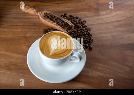 Grains de café rôtis avec cappuccino et motif mousse à pulsations Banque D'Images