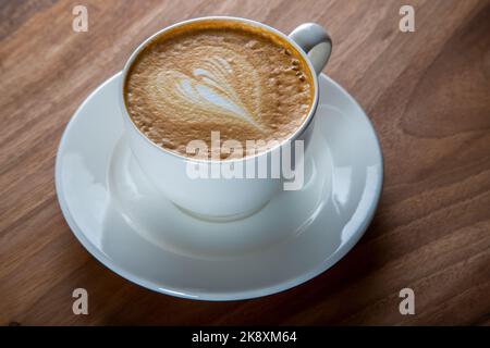 Une tasse de cappuccino sur une table en bois, vue sur le dessus Banque D'Images