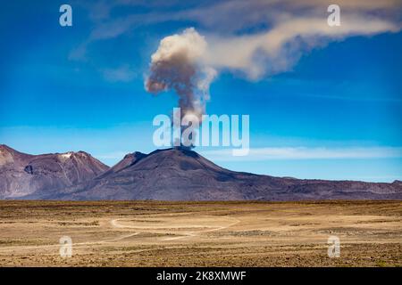 L'éruption du volcan actif Sabancaya le 09/20/2022 avec un panache de cendres dans le ciel bleu près de la ville de Chivay dans le canyon de Colca au Pérou. Banque D'Images