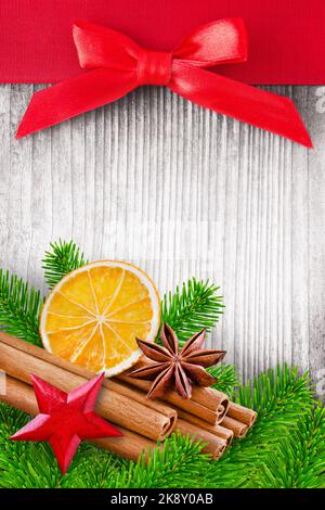 Dekoration für Weihnachten mit Stern, Tannenzweigen, Schleife, Zimt und Orangen auf Holz Banque D'Images