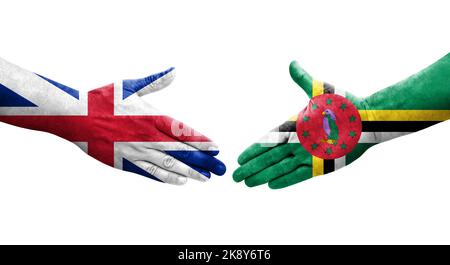 Poignée de main entre la Dominique et la Grande-Bretagne drapeaux peints sur les mains, image transparente isolée. Banque D'Images