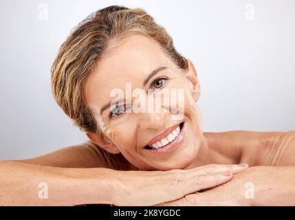 Femme senior, détendez-vous et beauté pour les soins de la peau avec le sourire pour les cosmétiques, le visage ou le traitement sur un fond gris studio. Portrait de personnes âgées heureuses Banque D'Images