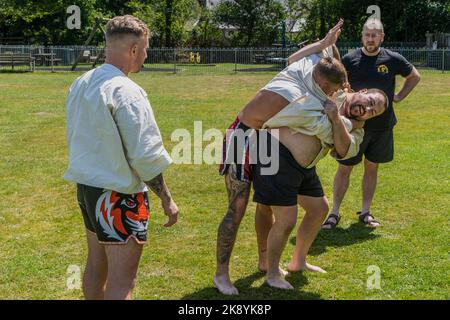 Les entraîneurs enseignent les règles et techniques de la Wrestling cornish avant le début du Grand Tournoi de la Wrestling cornish sur le village pittoresque g Banque D'Images