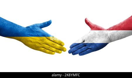 Poignée de main entre les pays-Bas et l'Ukraine drapeaux peints sur les mains, image transparente isolée. Banque D'Images