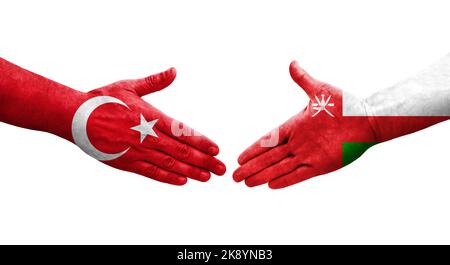 Poignée de main entre Oman et Turquie drapeaux peints sur les mains, image transparente isolée. Banque D'Images