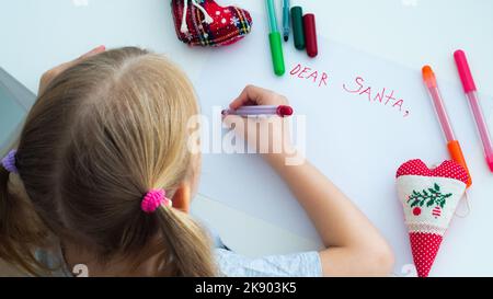 Petite fille écrivant la lettre de Noël à Santa Claus. Vue de dessus Banque D'Images