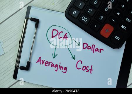 Concept de DCA - coût en dollars calcul de la moyenne écrire sur la paperasse avec la calculatrice isolée sur la table en bois. Banque D'Images