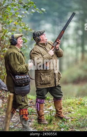 un homme qui tourne des faisans et son chargeur professionnel Banque D'Images