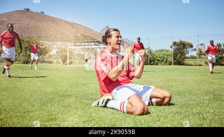 Joueur de football, applaudissent et gagnant poing dans la réussite de jeu, match de communauté ou entraînement d'énergie. Sourire, heureux et célébration pour le joueur de football Banque D'Images