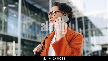 Femme d'affaires mature parlant au téléphone tout en se rendant au travail en ville. Femme d'affaires qui fait des plans pour la journée tout en marchant à son bureau Banque D'Images