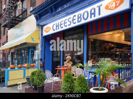 New York, NY - octobre 2022 : un visiteur effrayant d'Halloween s'assoit à une table à l'extérieur d'un café de Manhattan. Banque D'Images