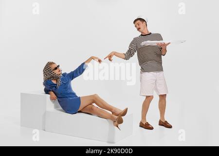 Portrait du jeune homme, marin servant la jeune belle femme isolée sur fond blanc. Célèbre pose de peinture Banque D'Images