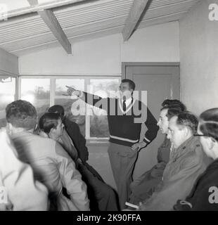 1959, historique, courses automobiles, Cooper Racing Drivers' School. Dans une cabine d'observation de Brands Hatch, Kent, Angleterre, Royaume-Uni, surplombant la piste, nouveaux pilotes ayant une réunion avant la course avec l'instructeur. Banque D'Images