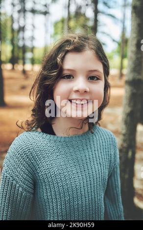 Nature, bonheur et portrait de l'enfant dans la forêt avec le sourire sur le visage Profitez du sentier de randonnée dans les bois. Liberté, aventure et arbres, bonne jeune fille Banque D'Images