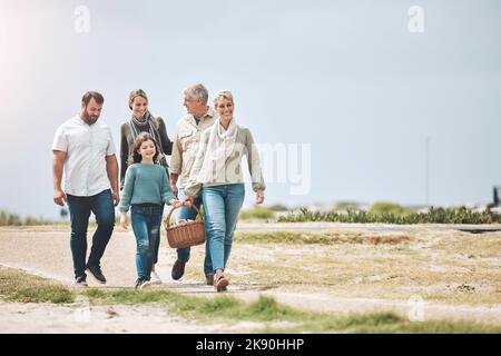 Grande famille, heureux et marche pour un pique-nique en vacances, vacances ou week-end à l'extérieur pour se détendre et se lier. Voyage de mère, de père et de grand-mère Banque D'Images