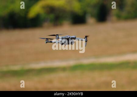 Vue de dessous rapprochée d'un petit drone volant dans l'air Banque D'Images