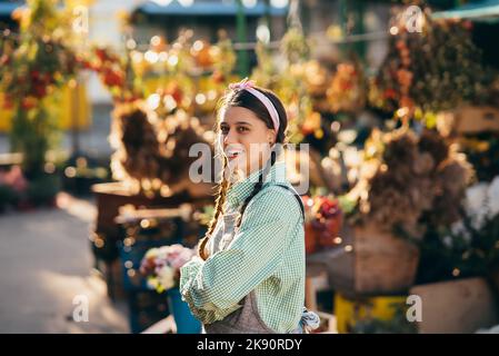 Bonne femme paysanne dans des combinaisons en denim souriant sincèrement en posant. Banque D'Images