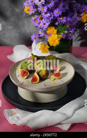 Figues fruits placés sur une petite assiette sur une table avec une nappe et le soleil Banque D'Images