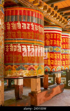 Vue verticale des moulins de prière bouddhistes colorés à Gom Kora ou du temple de Gomphu Kora près de Trashigang, dans l'est du Bhoutan Banque D'Images