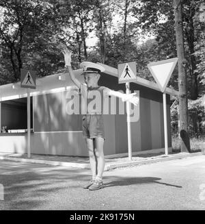 Dans le 1950s. Un garçon participe à une école de circulation où les enfants apprennent à se comporter dans la circulation. Les rues et les maisons sont plus petites que d'habitude dans l'exercice faire-croire-vrai dans le but de prévenir les accidents avec les enfants. Le garçon a emprunté un uniforme de policier-chapeau et des gants, et dirige la circulation dans le coin de rue fictif comme un vrai policier. L'année est 1958. Suède réf. CV79 Banque D'Images