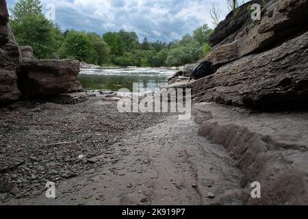 Une petite allée de sable avec de grands rochers allant à la rivière Banque D'Images
