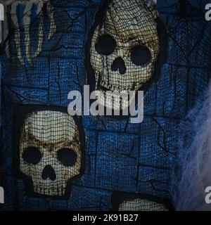 Décoration d'Halloween avec crânes et maille noire sur fond bleu foncé Banque D'Images