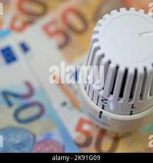 Thermostat devant les billets, symbolique des coûts de chauffage Banque D'Images