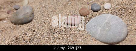 Pierre mise en forme de pied humain sur le sable, chaude journée d'été, côte, plage de sable Banque D'Images