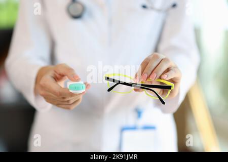 Femme médecin tenant des lunettes et un étui pour lentilles de contact Banque D'Images