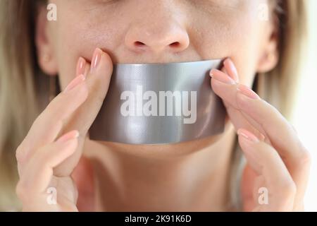 Jeune femme avec ruban de conduit scellé à la bouche Banque D'Images