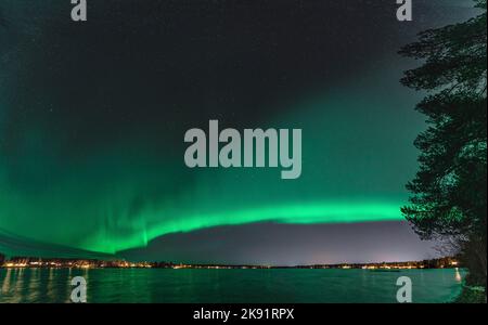 Panorama panoramique large Aurora, aurores boréales sur le lac Stocksjo de nuit calme dans le nord de la Suède, ville d'Umea. Reflet d'aurore dans la surface de l'eau. Banque D'Images