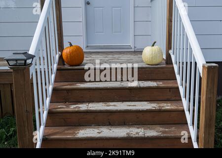 Une citrouille orange et bosselée, assise au sommet d'un escalier extérieur. Banque D'Images