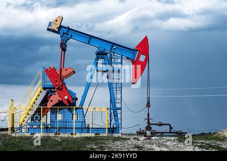 Extraction de pétrole brut dans le champ pétrolifère. L'équipement de forage pétrolier pompe l'huile. L'industrie pétrolière, le pétrole et la crise économique. Ressources fossiles, questions écologiques. Banque D'Images