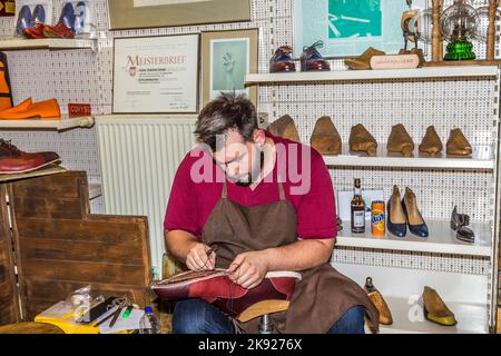 FRANCFORT, ALLEMAGNE - SEP 8, 2016: Le cordonnier ouvre son magasin à la fête annuelle de Bahnhofsviertel à Francfort. Il montre la main traditionnelle ho Banque D'Images