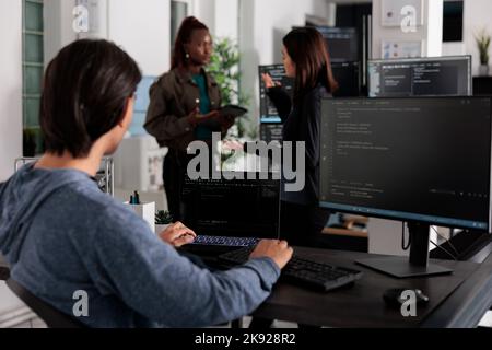 Développeur web asiatique analysant le code de compilation regardant l'ordinateur et l'ordinateur portable, travaillant sur le développement de nouvelles interfaces d'application. Programmeur utilisant une fenêtre de terminal avec des données de serveur de pare-feu dans le bureau Banque D'Images