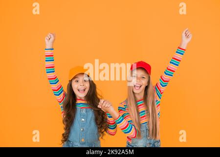 Les gagnants atteignent leur objectif. Les petits enfants excités font des gestes gagnants sur fond jaune. Les petits gagnants adorables apprécient le bonheur. Heureux gagnants Banque D'Images