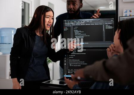 Divers développeurs de logiciels analysant le code html et la base de données, brainstorming des idées pour développer un nouveau système de sécurité. Ingénieurs système travaillant avec le langage de codage collaborant dans le bureau Big Data Banque D'Images