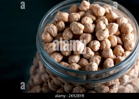 Haricots de Cheakpea dans un pot en verre sur la table en bois. Haricots de Cheakpea dans un plat en verre. Gros plan. Banque D'Images