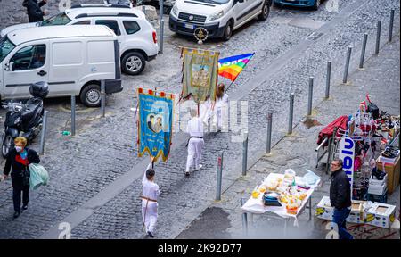 22 avril 2022-procession avec des personnes vêtues de blanc dans la rue de Naples portant de nombreuses bannières religieuses Banque D'Images