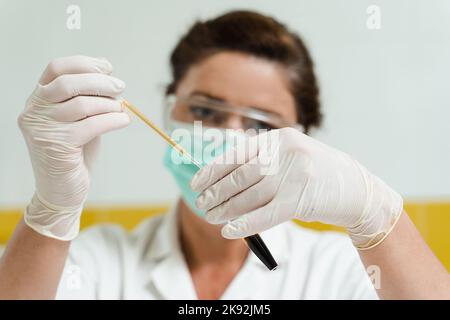 Analyse du plasma sanguin. L'assistant de laboratoire tient un tube à essai avec du sang d'une veine dans ses mains et le regarde. Test sanguin en laboratoire Banque D'Images