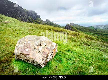 Quiraing,Isle of Skye,Scotland,UK-25 juillet 2022: Les randonneurs marchent le long des chemins de montagne de la chaîne de montagne de Quraing,un grand rocher en premier plan,o Banque D'Images