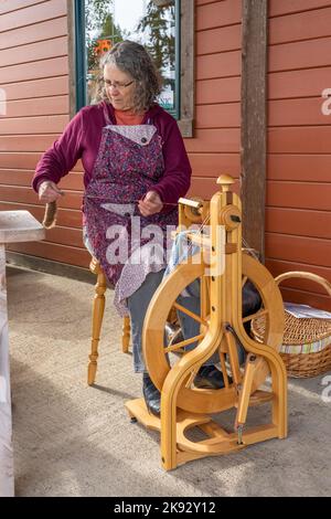 Port Townsend, Washington, États-Unis. Femme qui fait tourner de la laine sur une roue à double pédale. (Éditorial uniquement) Banque D'Images