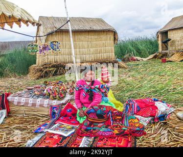 PUNO, PÉROU, 20 JANVIER 2015: Les îles Uros sur le lac Titicaca - les femmes locales dans le travail traditionnel de tenue vendent l'artisanat aux touristes à Puno, Pérou. Banque D'Images